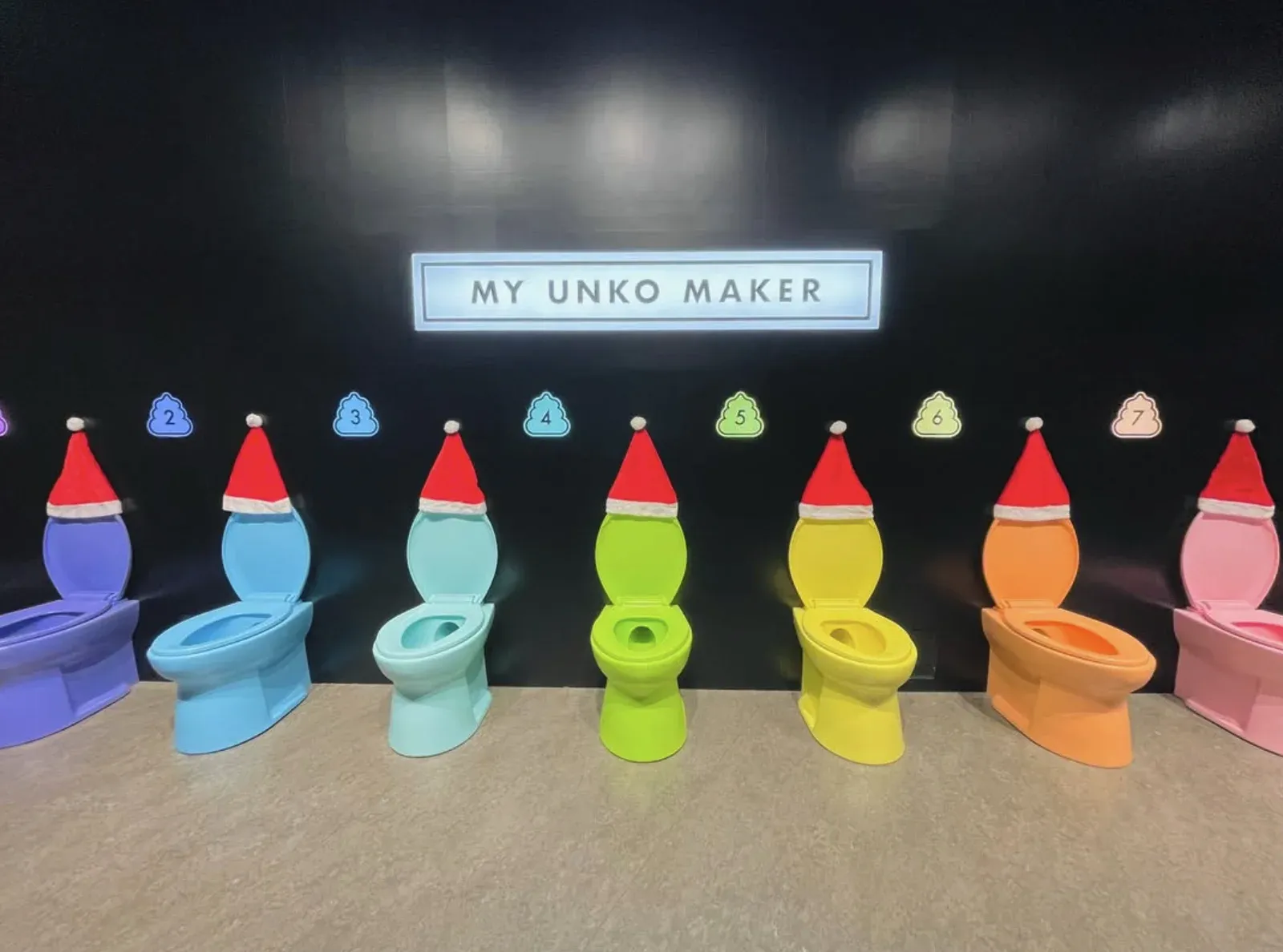Colorful toilets at the MY UNKO MAKER station, each topped with a Santa hat for the museum’s Christmas event.